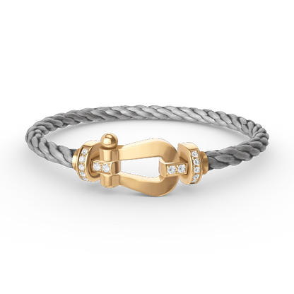 [Joyas Regalia]Pulsera de herradura grande con medio diamante en oro.