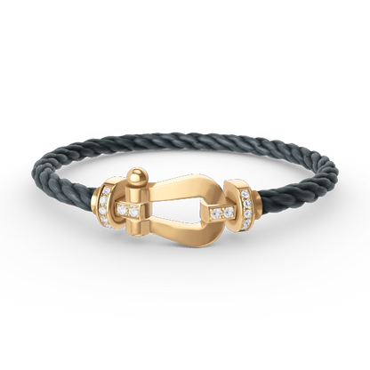 [Joyas Regalia]Pulsera de herradura grande con medio diamante en oro.