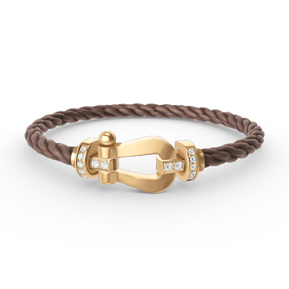 [Joyas Regalia]Pulsera de herradura grande con medio diamante en oro.